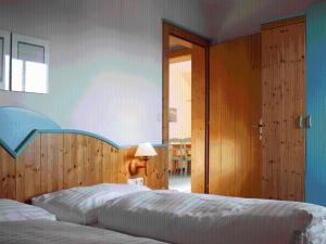 - une chambre avec 2 lits et une porte menant à une pièce dans l'établissement Sportpension Aichholzer, à Oberaichwald