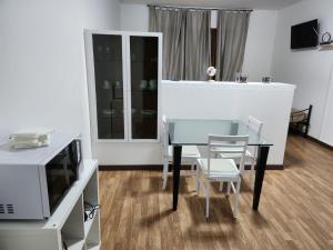 a dining room with a glass table and a television at Your home outlet 4 in Serravalle Scrivia