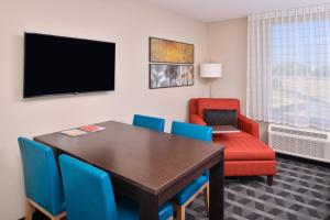 een eetkamer met een tafel en stoelen en een televisie bij TownePlace Suites by Marriott Ontario Chino Hills in Chino Hills