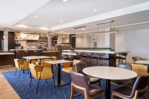 a restaurant with tables and chairs and a bar at Courtyard Salt Lake City Airport in Salt Lake City