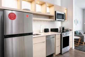 uma cozinha com um frigorífico de aço inoxidável e um micro-ondas em TownePlace Suites by Marriott Madison West, Middleton em Madison