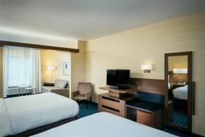 a hotel room with a bed and a desk with a television at Fairfield Inn & Suites by Marriott Tacoma DuPont in DuPont