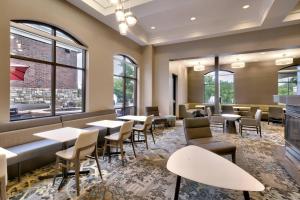 um restaurante com mesas, cadeiras e janelas em Residence Inn by Marriott Idaho Falls em Idaho Falls