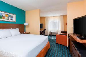 a hotel room with a bed and a flat screen tv at Fairfield Inn & Suites Lubbock in Lubbock