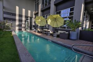 ein Hotel mit einem Pool mit Sonnenschirmen und Stühlen in der Unterkunft Fairfield Inn & Suites by Marriott Mexicali in Mexicali