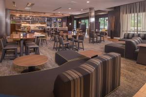a restaurant with couches and tables and a bar at Courtyard by Marriott Hershey Chocolate Avenue in Hershey