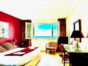 een hotelkamer met een bed, een bureau en een raam bij Hotel de l'Europe in Dieppe
