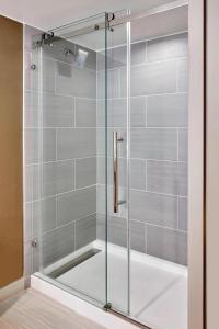 a shower with glass doors in a bathroom at Marriott Phoenix Airport in Phoenix
