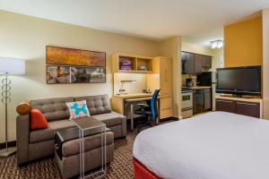 a hotel room with a bed a couch and a desk at TownePlace Suites Tampa Westshore/Airport in Tampa