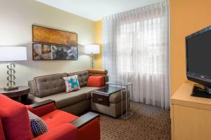 a living room with a couch and a flat screen tv at TownePlace Suites Tampa Westshore/Airport in Tampa