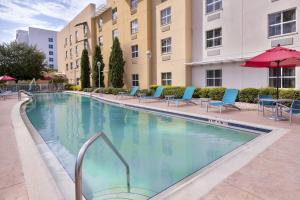 a large swimming pool with blue chairs and a building at TownePlace Suites Tampa Westshore/Airport in Tampa
