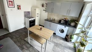 a small kitchen with a table and a refrigerator at Millfields Place in London