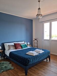1 dormitorio azul con 1 cama con pared azul en NEW Pascasio Suite: charming stays at the doors of Udine, en Pasian di Prato