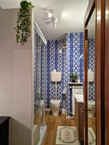 uma casa de banho com uma parede em azulejo azul e branco em NEW Pascasio Suite: charming stays at the doors of Udine em Pasian di Prato
