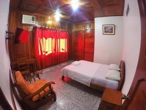 ein kleines Schlafzimmer mit einem Bett und einem Stuhl in der Unterkunft Bello-Oriente-I in Iquitos