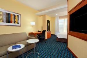 a hotel room with a couch and a bed and a desk at Fairfield Inn & Suites by Marriott Fairfield Napa Valley Area in Fairfield