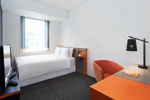 a hotel room with a bed and a desk at Courtyard by Marriott Tokyo Station in Tokyo