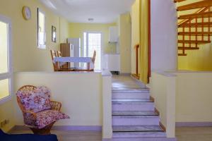 a hallway with stairs and a chair and a kitchen at Casa del sol 2 bedrooms in Morro del Jable