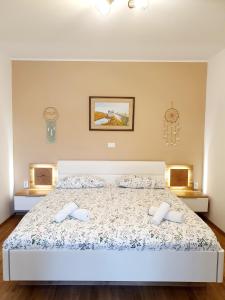 a bedroom with a bed with two white shoes on it at Harmony apartments in Portorož