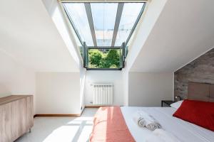 una camera da letto con un grande letto con una grande finestra di Mansarda Romantica a Rapallo