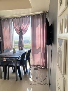 a table and chairs in a room with a window at 180 degree view of manila bay in Manila