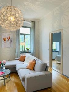 uma sala de estar com um sofá e um lustre em Ferienwohnung im Gästehaus em Meissen