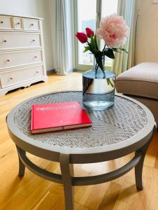 a table with a vase of flowers and a book at Ferienwohnung im Gästehaus in Meißen