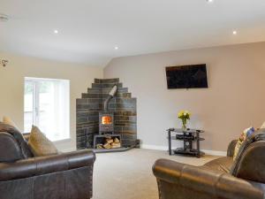 uma sala de estar com dois sofás e uma lareira em Hameish Holiday Cottage em Kirkcudbright