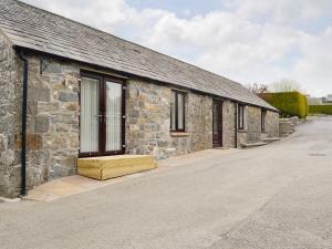 un edificio de piedra con una ventana en el lateral. en Hameish Holiday Cottage, en Kirkcudbright