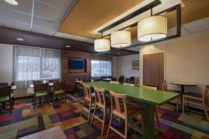 une salle à manger avec une table et des chaises vertes dans l'établissement Fairfield Inn Saint Louis Collinsville, à Collinsville