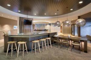 una cucina con bar e una sala da pranzo con sgabelli di Springhill Suites by Marriott Vernal a Vernal