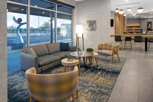 a living room with a couch and tables and chairs at TownePlace Suites by Marriott Phoenix Glendale Sports & Entertainment District in Glendale