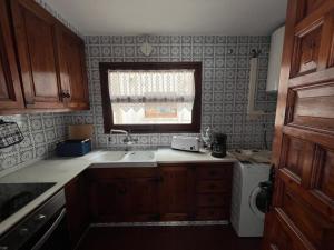 una pequeña cocina con fregadero y ventana en Sea breeze, en Vilanova i la Geltrú