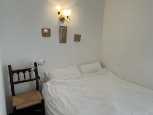 a bedroom with a white bed and a light on the wall at Sea breeze in Vilanova i la Geltrú