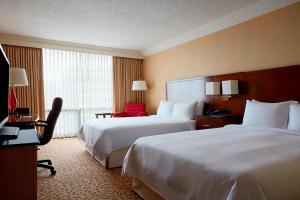 a hotel room with two beds and a desk at Stamford Marriott Hotel & Spa in Stamford