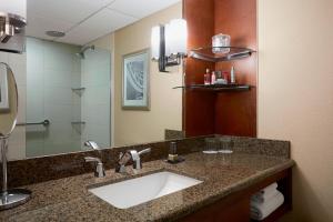 La salle de bains est pourvue d'un lavabo et d'un miroir. dans l'établissement Stamford Marriott Hotel & Spa, à Stamford