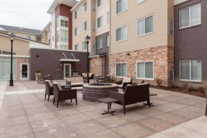 een patio met stoelen en tafels en een vuurplaats bij Residence Inn by Marriott St. Louis West County in Saint Louis