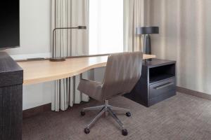 a desk with a chair and a desk with a lamp at Residence Inn by Marriott St. Louis West County in Saint Louis +10 photos