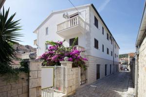 a white building with flowers on the side of it at Apartment in Hvar town historic center in Hvar