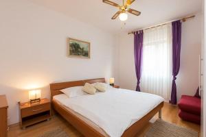 a bedroom with a bed and a window with purple curtains at Apartment in Hvar town historic center in Hvar