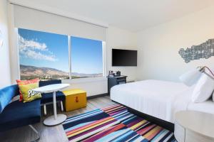 a hotel room with a bed and a large window at Aloft by Marriott Reno Tahoe International Airport in Reno