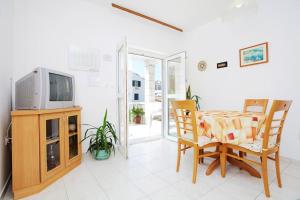 a living room with a tv and a table and chairs at Apartment in Hvar town historic center in Hvar