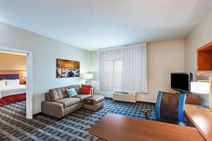 een hotelkamer met een bank en een bed bij TownePlace Suites by Marriott Tulsa North/Owasso in Owasso