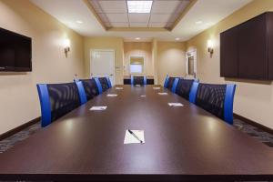 a conference room with a long table and blue chairs at TownePlace Suites by Marriott Tulsa North/Owasso in Owasso