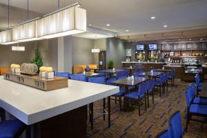 a restaurant with blue chairs and tables and a bar at TownePlace Suites by Marriott Toronto Northeast/Markham in Markham