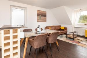 uma cozinha e sala de estar com mesa e cadeiras em Wohnung Bontje em Juist