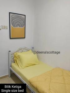 ein Bett mit einem gelben Kissen und einem Bild an der Wand in der Unterkunft Deena's Cottage Kulim Hitech Hospital Kulim, Three-bedrooms Single Storey Terrace House in Kulim