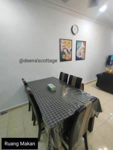 uma mesa de jantar com cadeiras e um relógio na parede em Deena's Cottage Kulim Hitech Hospital Kulim, Three-bedrooms Single Storey Terrace House em Kulim