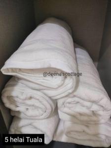a stack of white towels sitting on a bed at Deena's Cottage Homestay Kulim Hitech Hospital Kulim, Three bedrooms Single Storey Terrace House in Kulim +11 photos