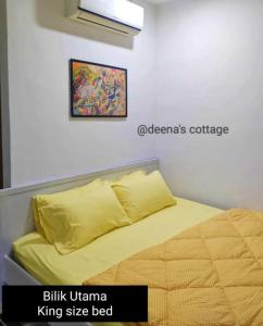 Un dormitorio con una cama amarilla y una foto en la pared en Deena's Cottage Kulim Hitech Hospital Kulim, Three-bedrooms Single Storey Terrace House en Kulim